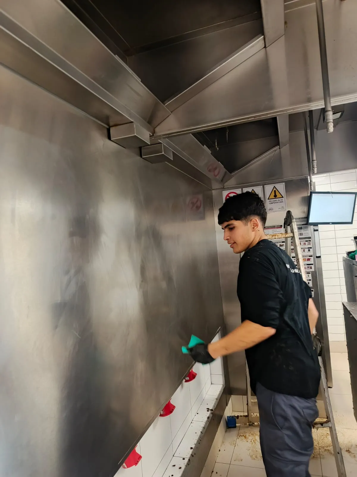 Técnico INGEGAR limpiando interior de campana extractora en cocina industrial