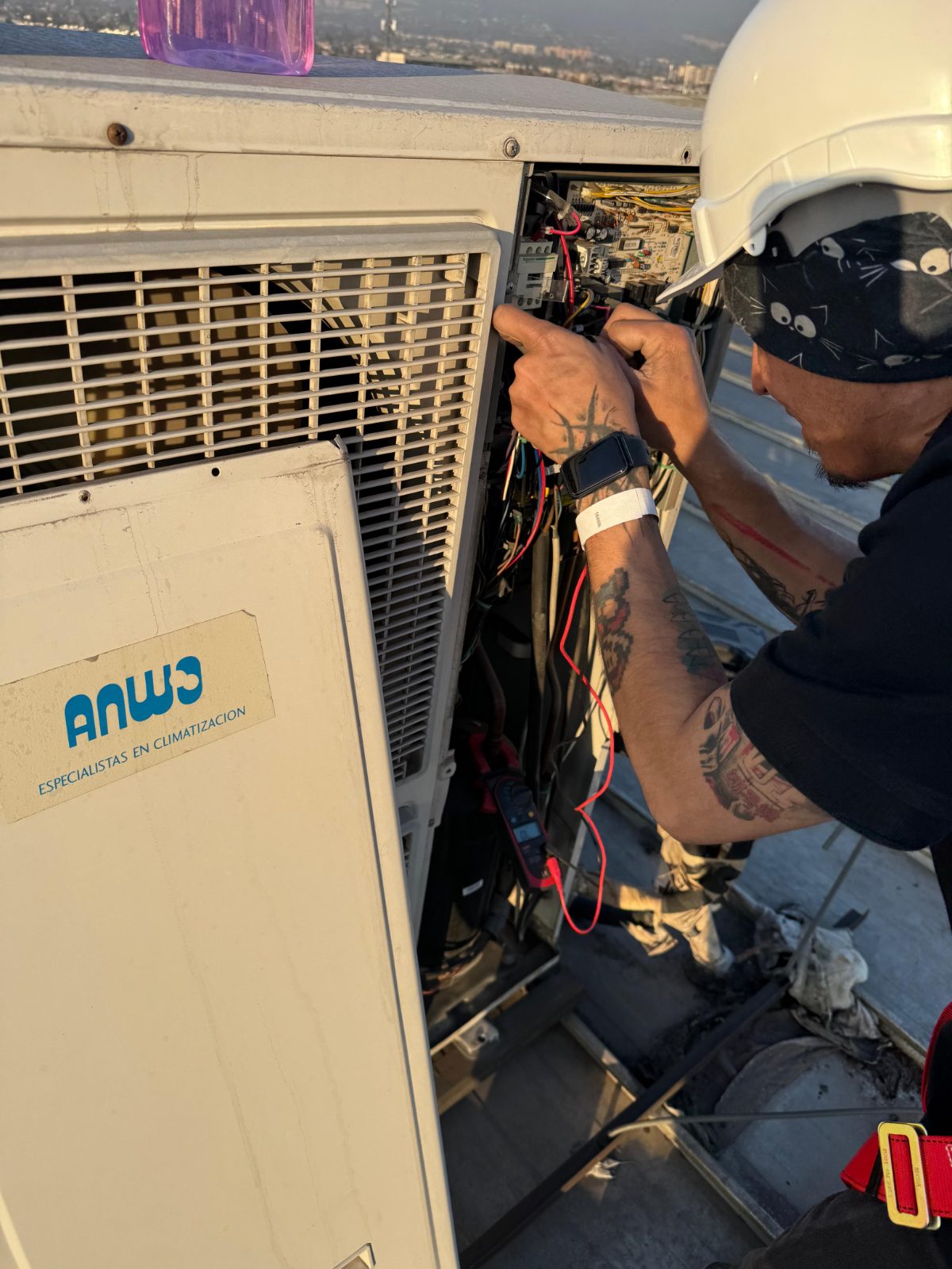 Técnico INGEGAR con casco reparando el tablero interno de una unidad exterior HVAC