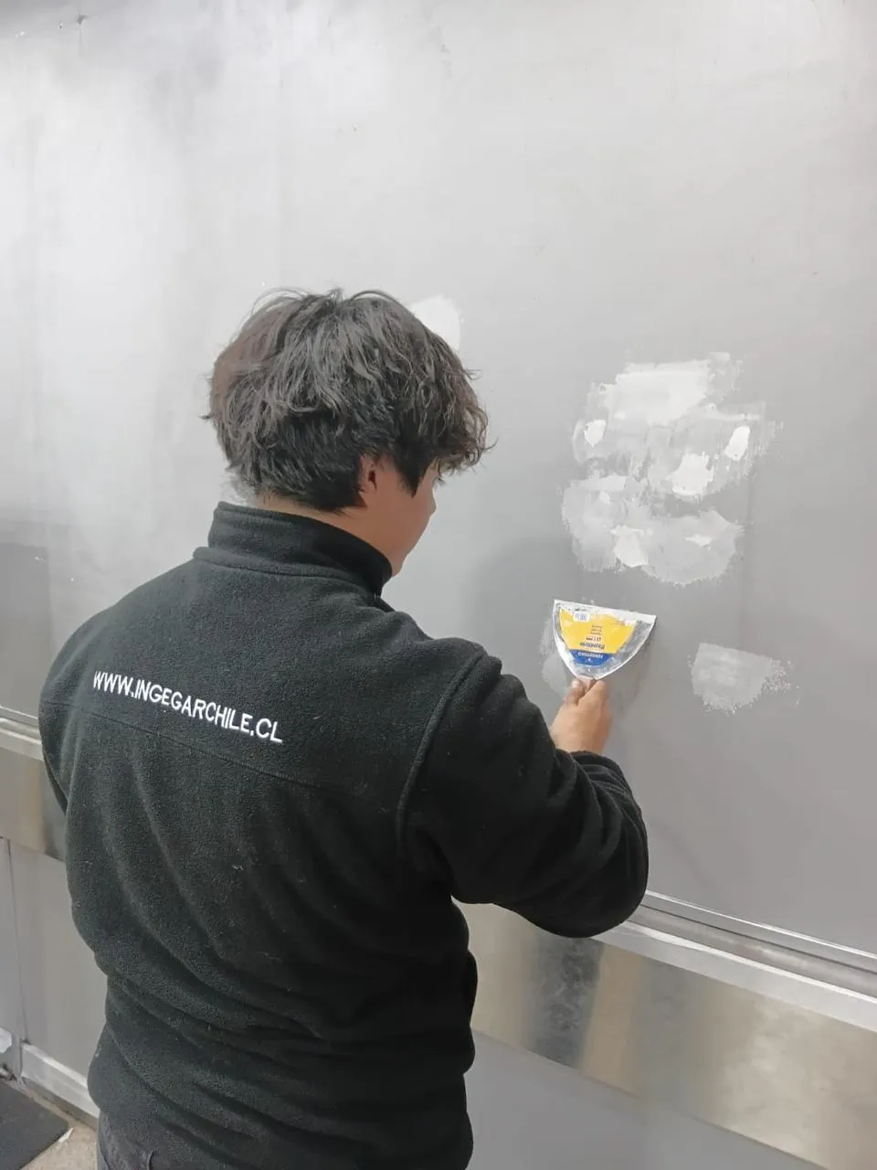 Técnico INGEGAR realizando pintura y revestimiento en local comercial de Santiago