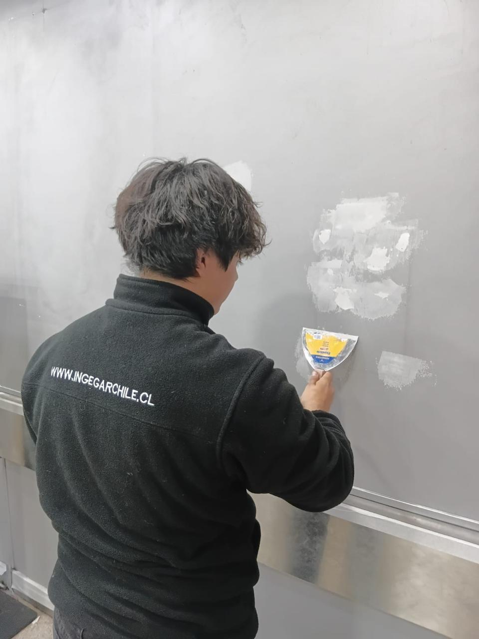 Técnico INGEGAR reparando y emplastando muro en local comercial, Santiago RM